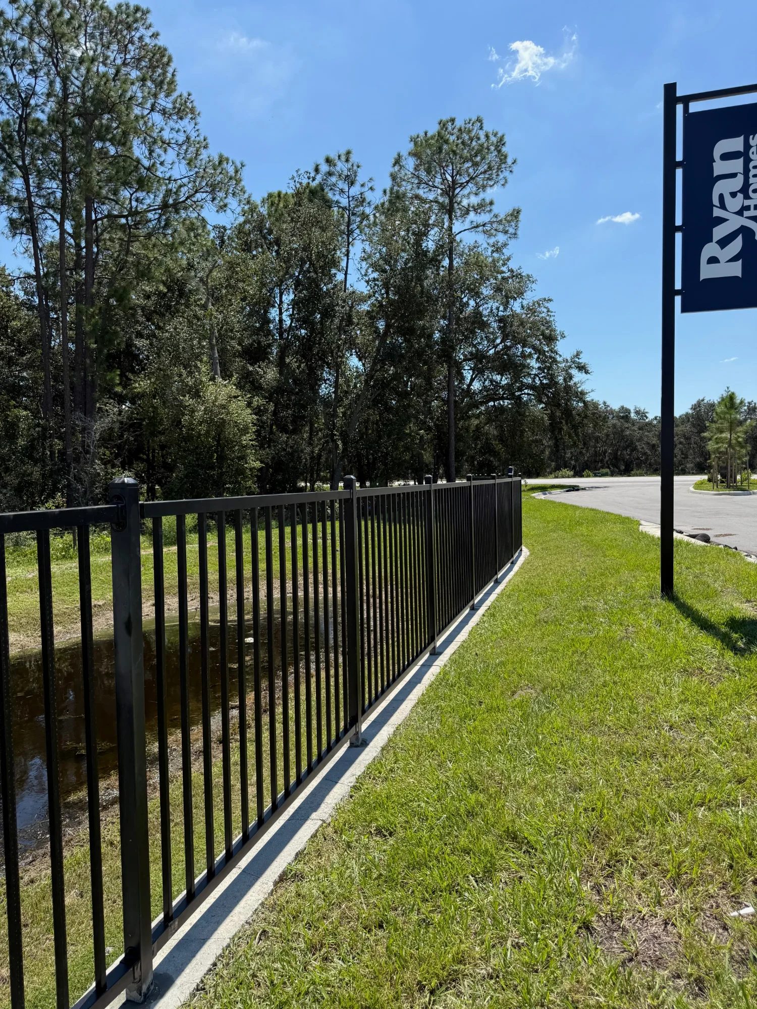 Black aluminum fence installation Florida retention pond commercial property