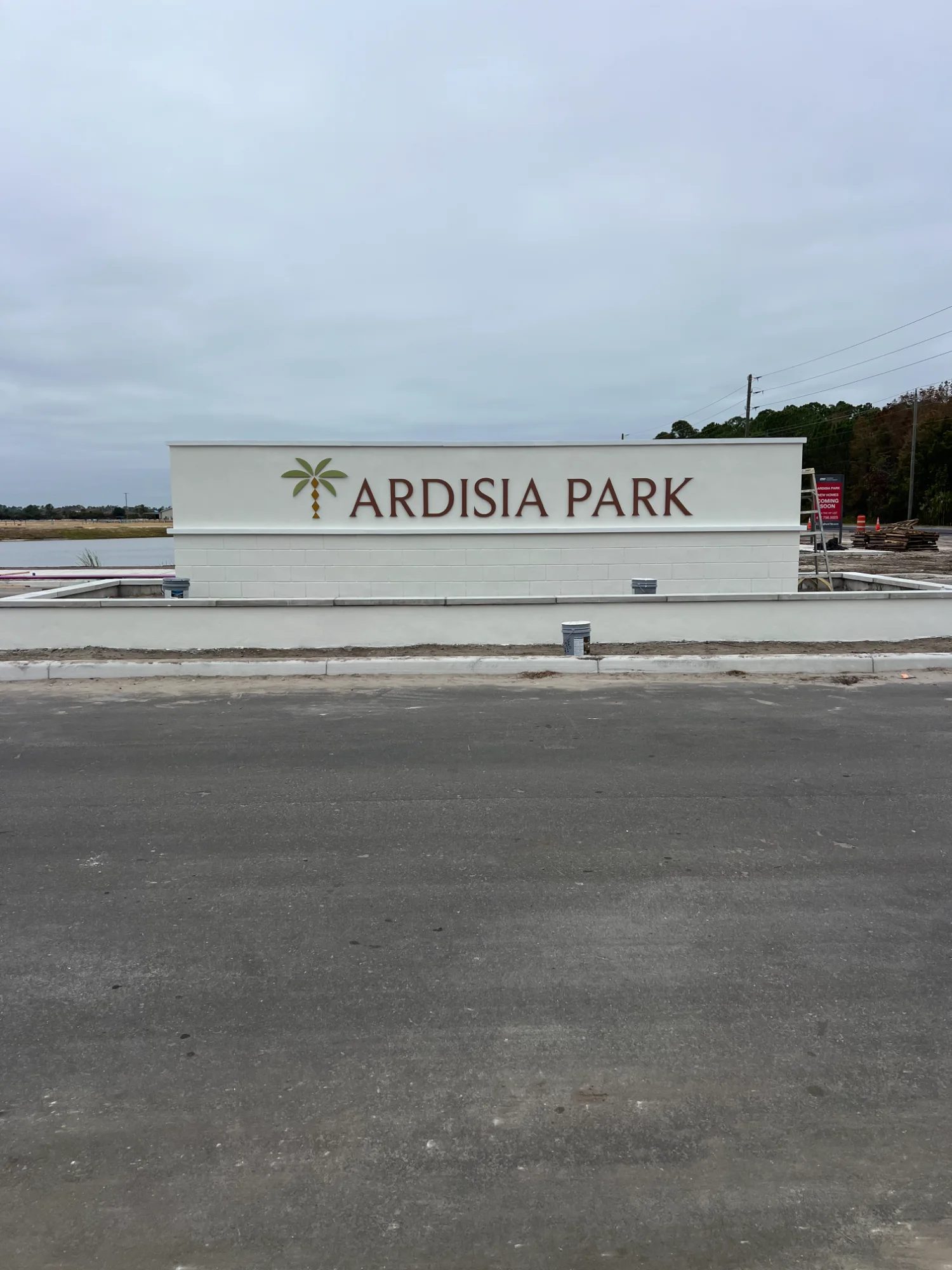 White precast concrete monument sign at community entrance in Florida