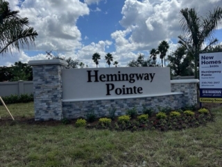curved-monument-sign-hemingway-pointe-florida Curved white monument sign with gray stacked stone pillars Hemingway Pointe Florida