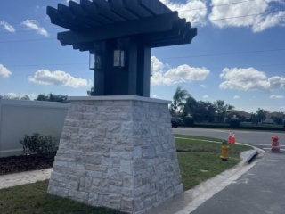 decorative-entry-pillar-stone-pergola-florida Decorative stone entry pillar with black pergola and wall lanterns Florida