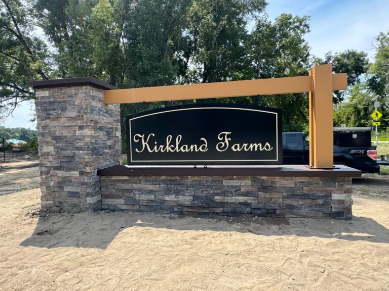 Stone monument sign with hanging panel and copper pergola Kirkland Farms Florida