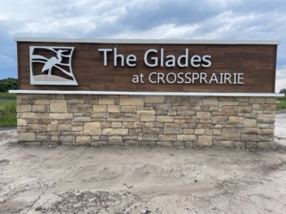 wood-stone-monument-sign-glades-crossprarie-florida Wood panel monument sign with stone base and bird logo The Glades at Crossprarie Florida